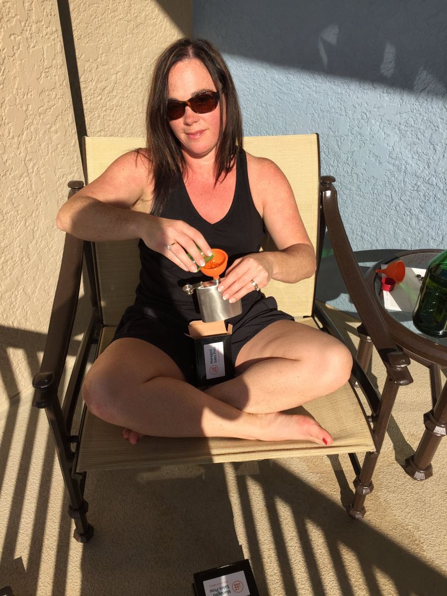 Tracie on a sunny balcony with a funnel and a flask