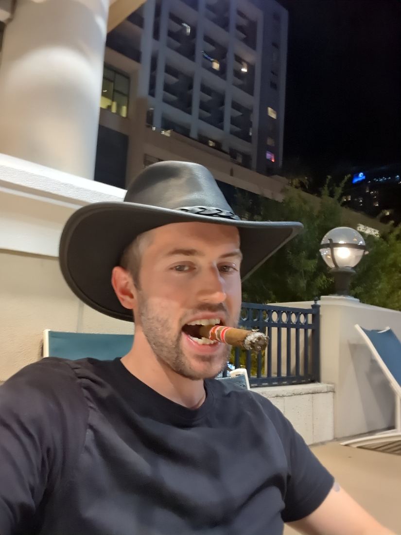 Ian in a wide-brim hat with a cigar between his teeth