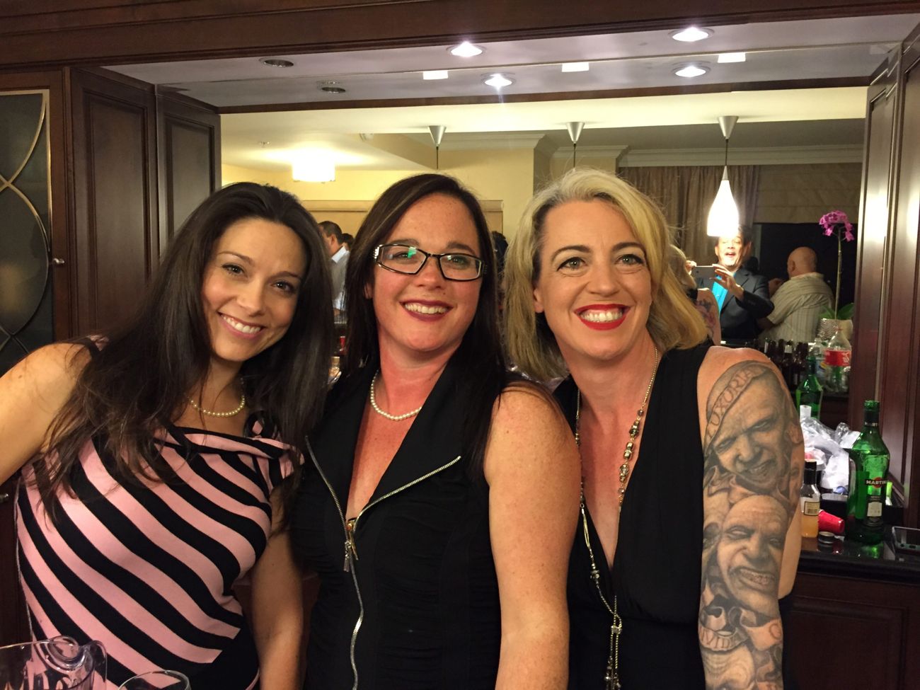 Three friends smiling at the suite bar